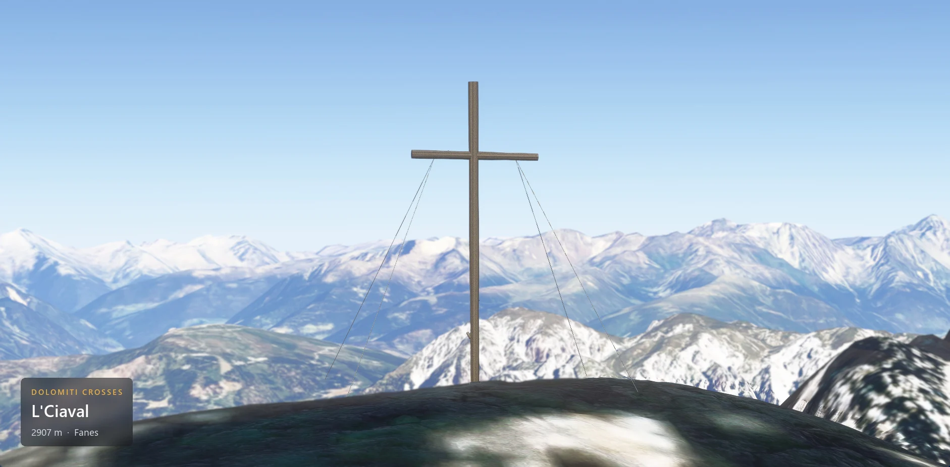 The summit cross on L'Ciaval (2907 m) seen from the front, with the caption plate in the lower left corner.