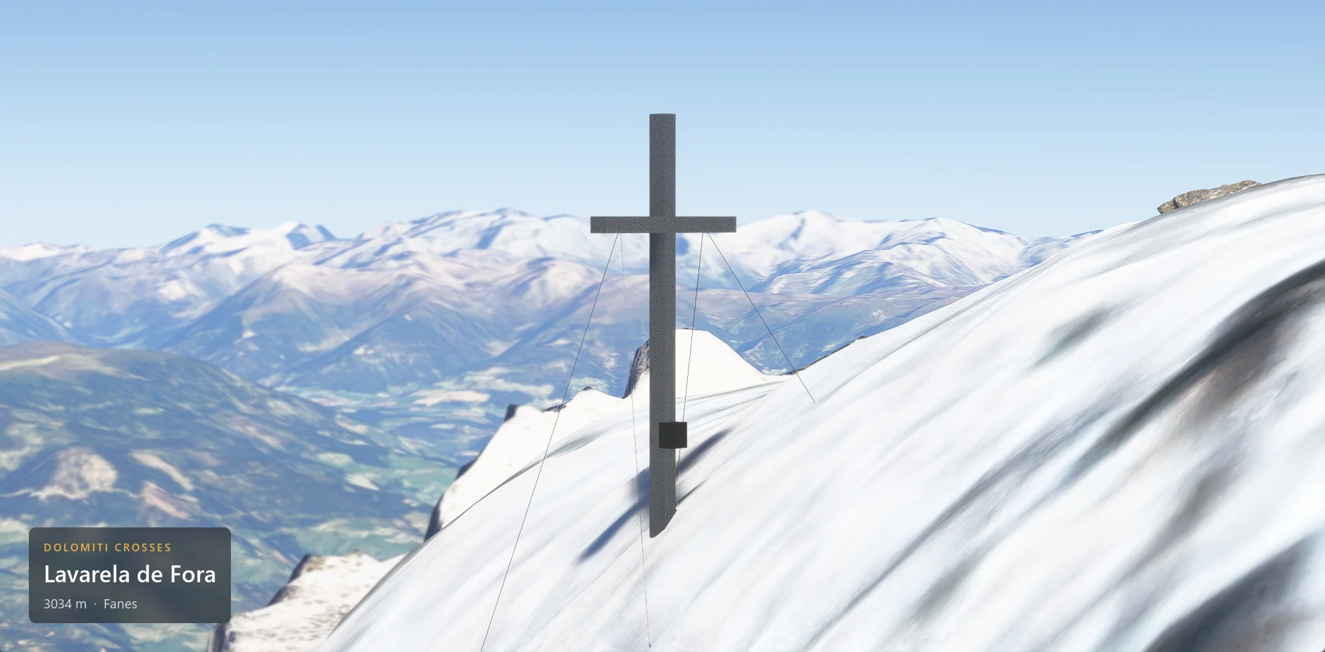 The summit cross on Lavarela de Fora (3034 m) seen from the side, with the caption plate in the lower left corner.