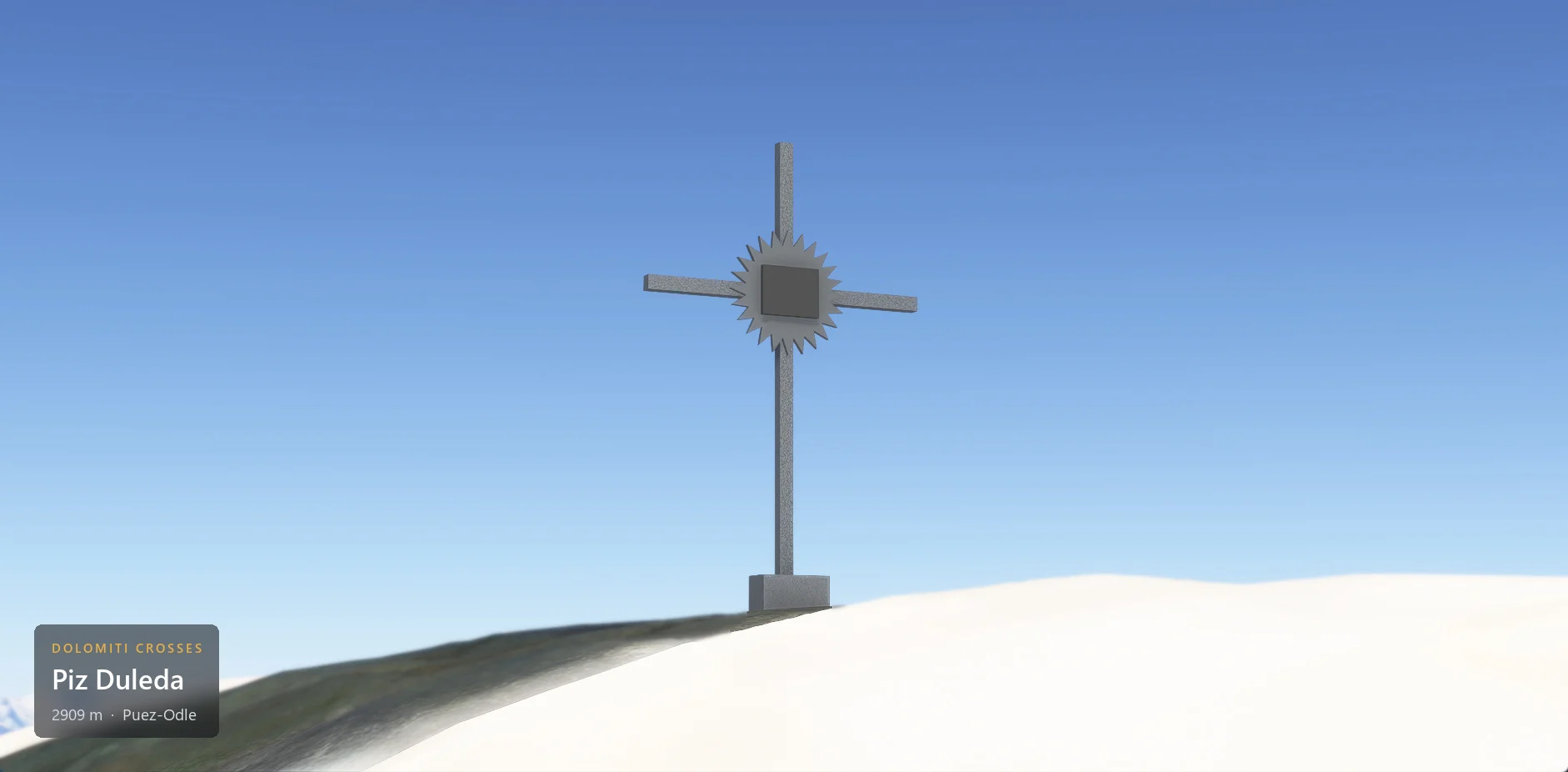 The summit cross on Piz Duleda (2909 m) seen from below against the sky, with the caption plate in the lower left corner.