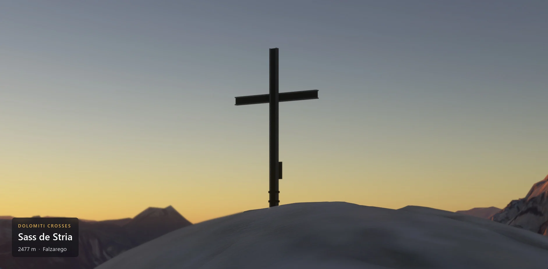 The summit cross on Sass de Stria (2477 m) against the evening light, with the caption plate in the lower left corner.